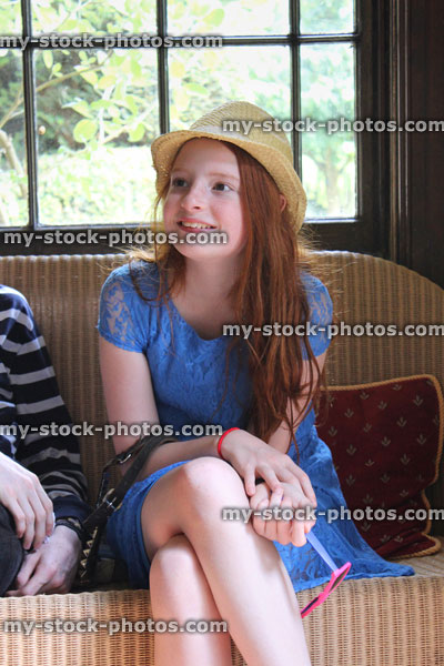 Stock image of girl sitting down with long hair, hat, window