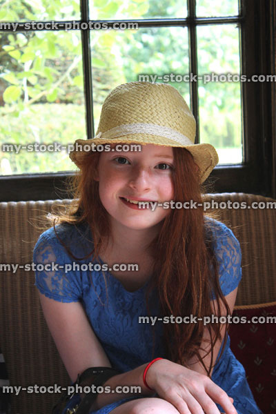 Stock image of girl sitting down with long hair, hat, window