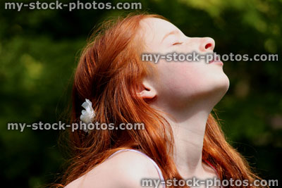 Stock image of attractive young girl enjoying the sunshine in garden (close up)