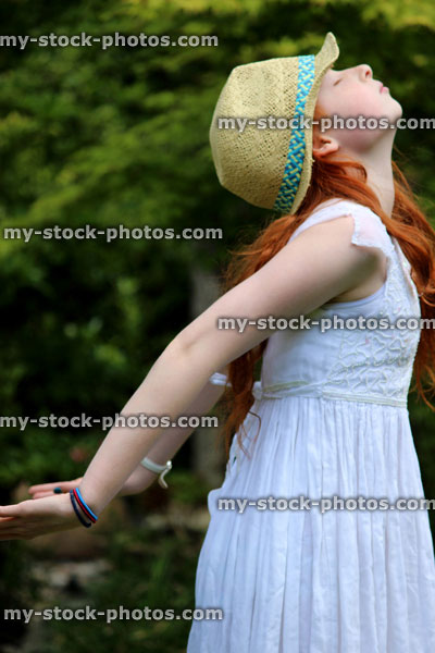 Stock image of attractive young girl enjoying the sun in garden, white dress