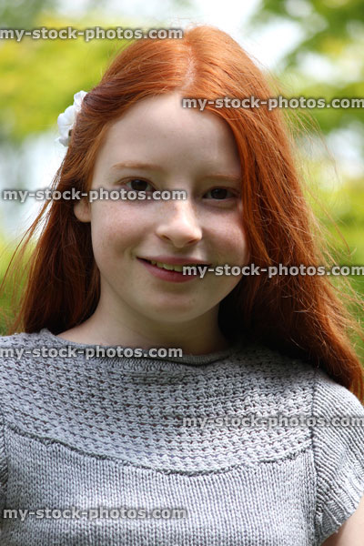 Stock image of pretty, happy girl with long red hair, garden