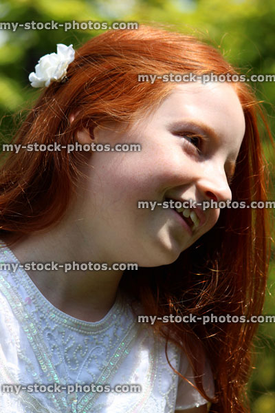 Stock image of attractive, happy girl with long red hair relaxing in summer