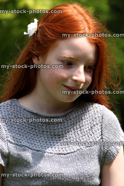 Stock image of pretty, happy girl with long red hair on a sunny summer's afternoon