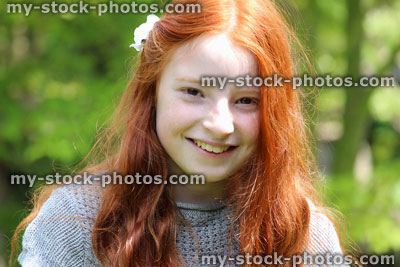 Stock image of beautiful, happy girl with long red hair in the sunshine