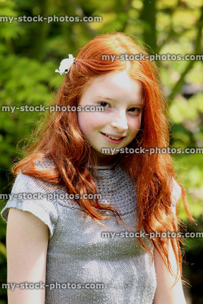Stock image of attractive, happy girl with long red hair