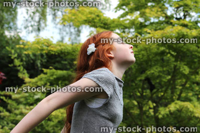 Stock image of attractive young girl enjoying the sunshine in garden