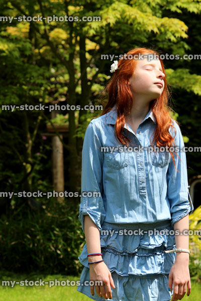 Stock image of pretty young girl enjoying the sunshine in garden