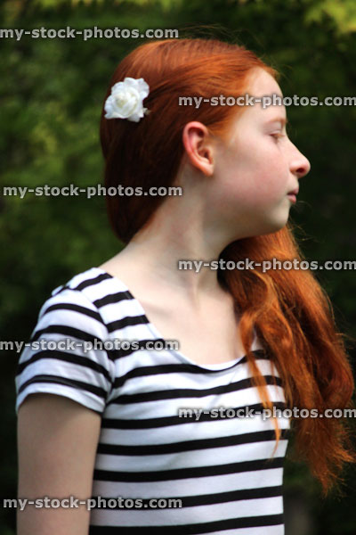 Stock image of girl with long hair looking sideways in garden