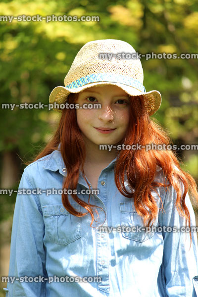 Stock image of beautiful young happy girl in the garden sunshine wearing straw hat