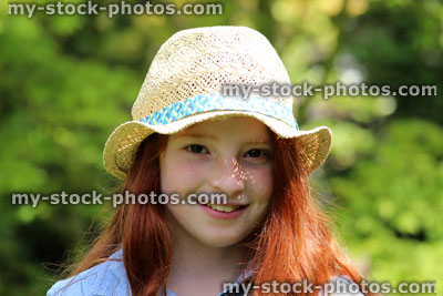 Stock image of pretty young happy girl in the garden sunshine wearing straw hat