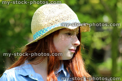 Stock image of attractive young happy girl in the garden sunshine wearing straw hat