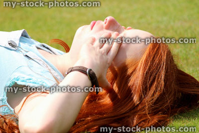 Stock image of girl sleeping / daydreaming / dreaming / sunbathing / hands on eyes / garden lawn