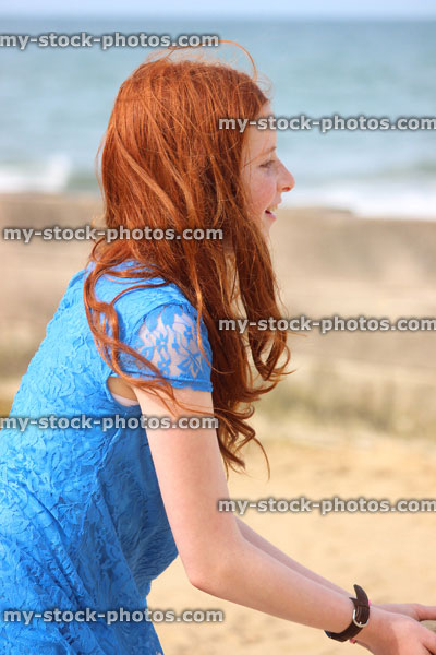 Stock image of girl standing on beach by sea, seaside summer holiday, daydreaming