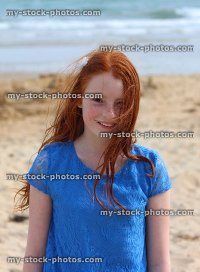 Stock image of girl standing on beach by sea, seaside summer holiday, blue dress