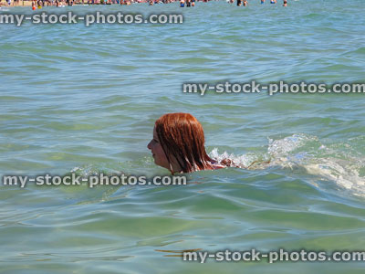 Stock image of girl swimming in warm sea close to beach