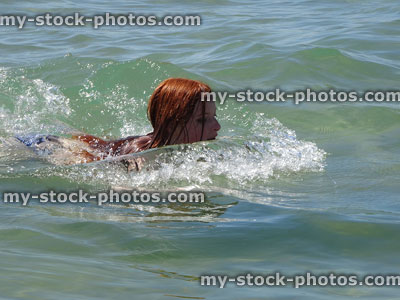 Stock image of girl swimming and splashing in sea water, breaststroke