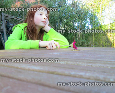 Stock image of girl looking along wooden table in garden, perspective photo