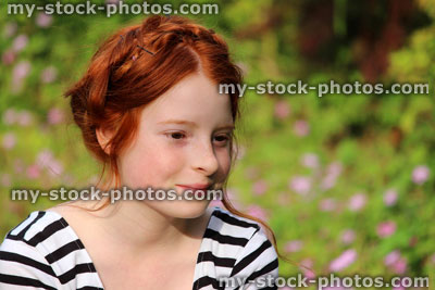 Stock image of girl in garden, smiling with milkmaid braid hairstyle