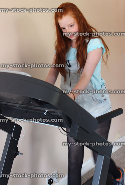 Stock image of girl walking / exercising on treadmill fitness running machine, keep fit