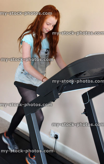 Stock image of girl walking / exercising on treadmill fitness running machine, keep fit