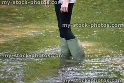 Stock image of girl playing, paddling, splashing, wading in woodland river