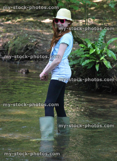 Stock image of girl playing, paddling, wading in river, woodland stream