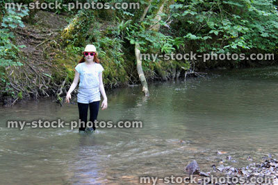 Stock image of girl playing / paddling / wading in river, woodland stream