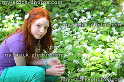 Stock image of girl smelling white flowers on wild garlic