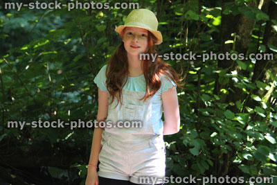 Stock image of girl in woodland forest, straw hat, standing, posing and daydreaming