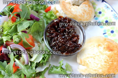 Stock image of English muffins with grilled goat's cheese, salad, onion marmalade relish