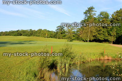 Stock image of pond at landscaped golf course, natural water hazard
