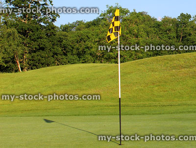 Stock image of golf course with putting green, flag, hole, fine grass