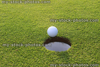 Stock image of ball by putting green hole on golf course