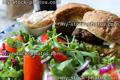 Stock image of homemade gourmet lamb burger, brie cheese, jelly mint sauce, salad