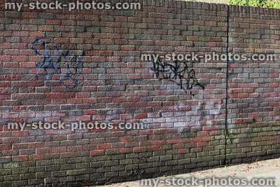 Stock image of old wall made from textured red bricks, graffiti tags