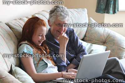 Stock image of girl showing grandmother how to use laptop computer