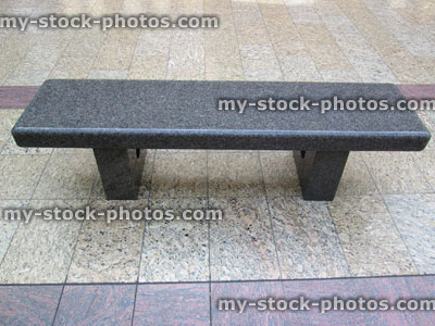 Stock image of shiny grey granite bench on tiled stone floor
