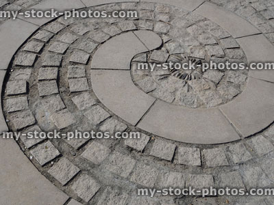 Stock image of ammonite shaped patio, spiral of paving slabs, granite blocks