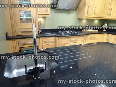 Stock image of sink and draining-board on black granite kitchen worktop