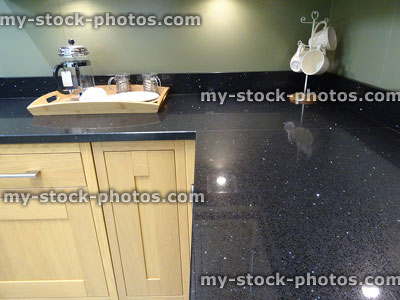 Stock image of black sparkly granite worktop corner in fitted kitchen