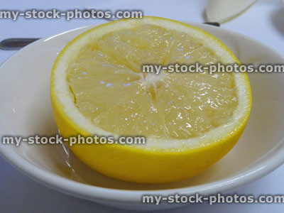 Stock image of sliced grapefruit half, white bowl / dish, served as healthy breakfast