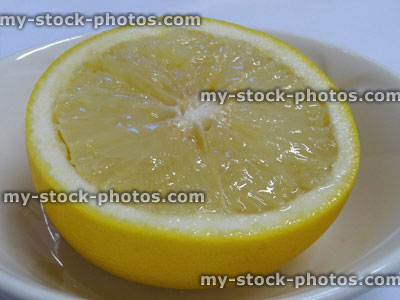 Stock image of sliced grapefruit half, white bowl / dish, served as healthy breakfast