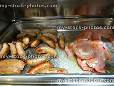 Stock image of greasy sausages / bacon platter, unhealthy full English breakfast buffet