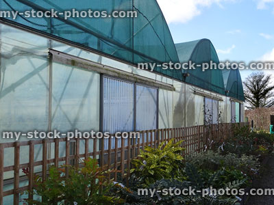 Stock image of commercial polytunnels / greenhouses covered with green netting / shading