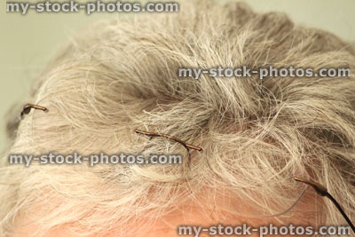 Stock image of old lady with grey hair, rimless glasses on head, senior pensioner