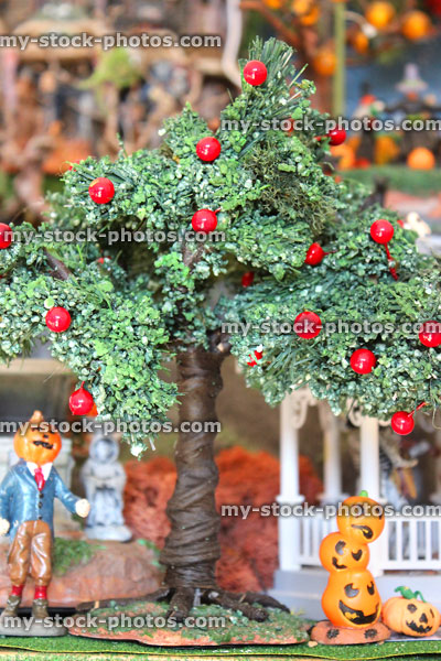 Stock image of miniature apple tree in model Halloween village, pumpkin-stack