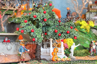 Stock image of pumpkin head man, apple-tree and model Halloween village