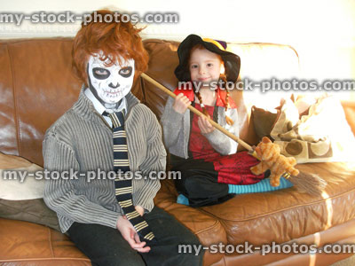 Stock image of boy and girl in Halloween costumes, witch / skull