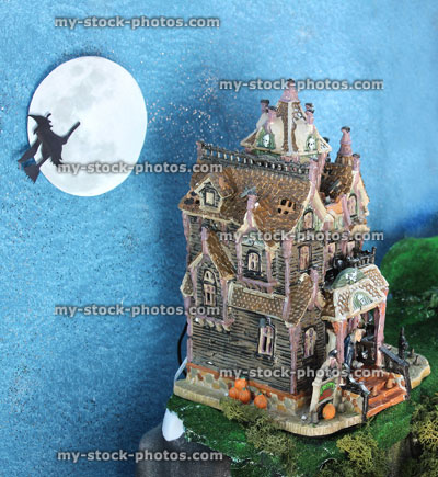 Stock image of model Halloween spooky town, miniature people, haunted house, flying witch, broomstick, full moon