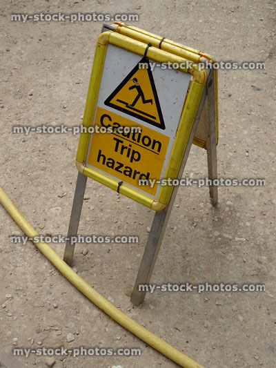 Stock image of sandwich board warning sign, hose pipe 'Caution trip hazard'
